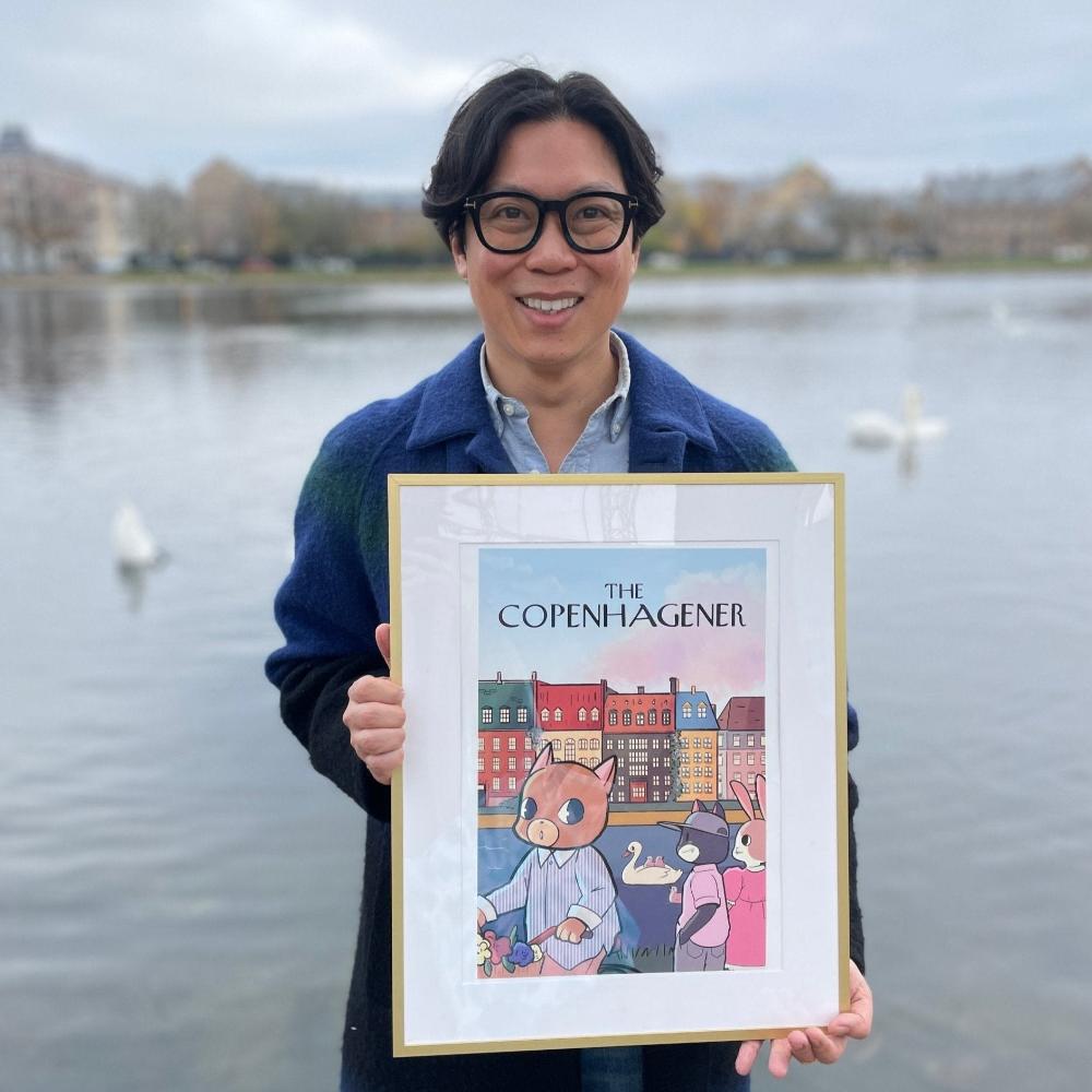 Artist Simon Ip proudly showing his framed art by the Copenhagen Lakes